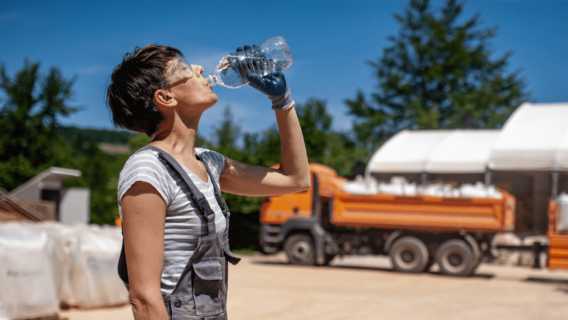 Female laborer drinking water in extreme heat