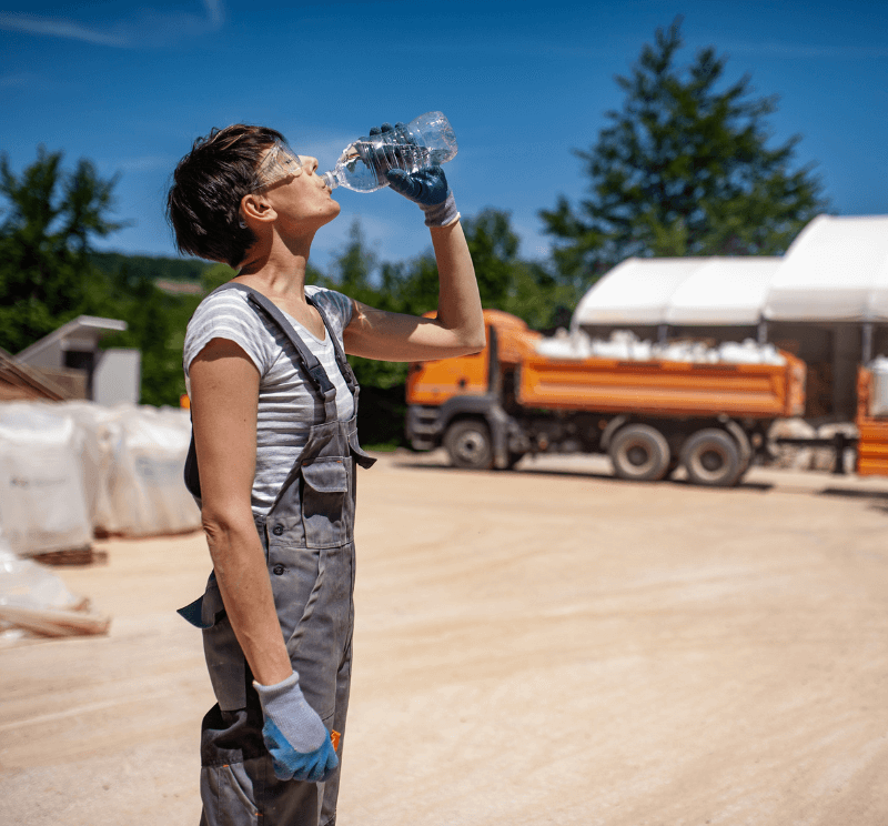 Female laborer drinking water in extreme heat