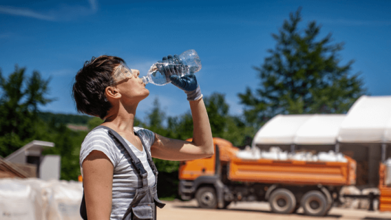 Female laborer drinking water in extreme heat