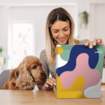 Woman with dog opening Branded Merchandise Kit from HALO