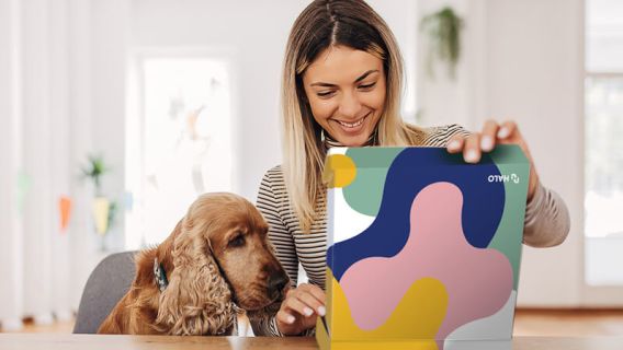 Woman with dog opening Branded Merchandise Kit from HALO