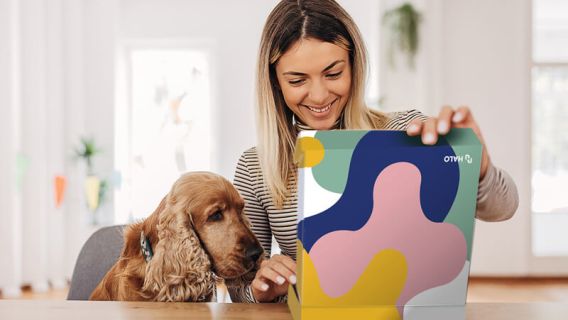 Woman with dog opening Branded Merchandise Kit from HALO