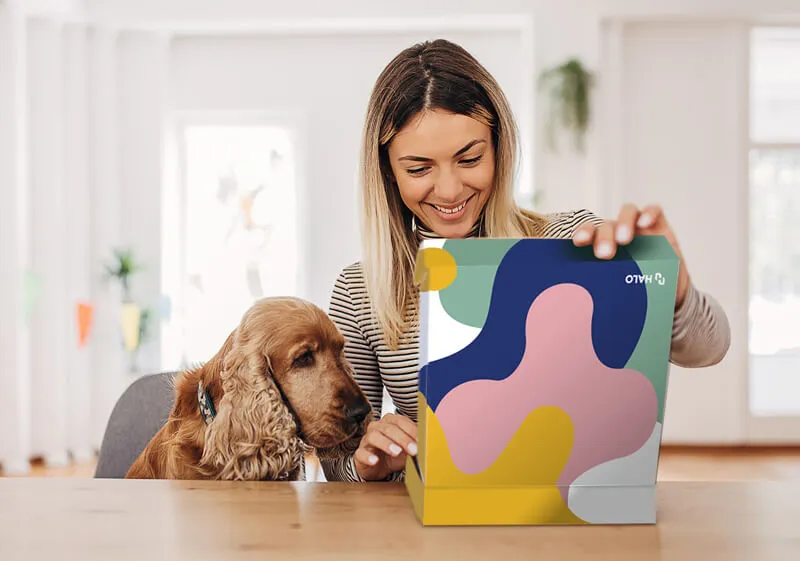 Woman with dog opening Branded Merchandise Kit from HALO